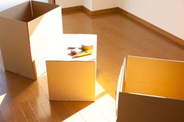 Boş odadaki karton kutudaki araçların yakın görüntüsü. yeni ev kavramı        