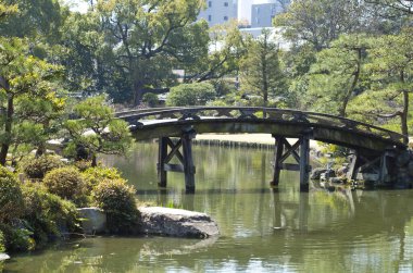 Nehrin üzerinde ahşap köprüsü olan park 