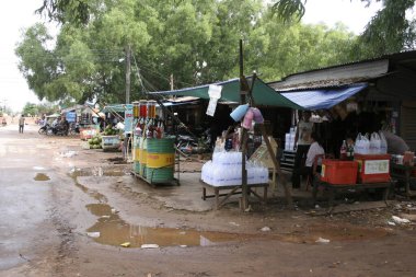 Açık pazar tezgahları muşambaların altında mal satıyor.