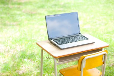 Laptopu yeşil alandaki açık masada kapat.