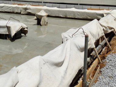Beton temel koruyucu beyaz kumaş altında tedavi açık havada kaplar