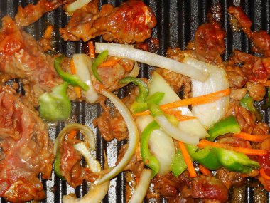 Cızırdayan et dilimleri soğan biberli havuç ve sebze ızgarası.