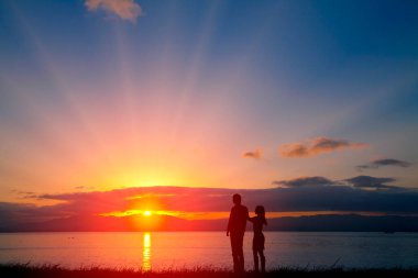silhouette of happy young couple on a beautiful sunset background