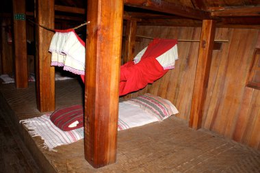 Ahşap iç döşeme, hamakları ve yatakları gösteriyor.