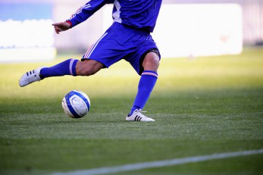 Spor giyim sektöründe futbol oyuncusunun bacakları çimlerin üzerinde top oynuyor.                 