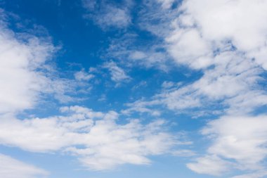 Mavi gökyüzü arka planında beyaz tüylü kümülüs bulutları       