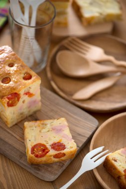 Mutfak masasında peynirli, jambonlu ve sebzeli lezzetli ev yapımı ekmeğin yakın plan görüntüsü.        