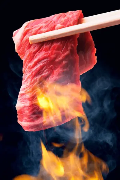 バーベキューや和風の焼肉をスライスした牛肉の箸のクローズアップビュー — ストック写真