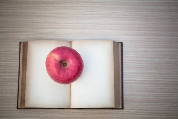 Masanın Üstündeki Kitabın Üstünde Kırmızı Elma — Stok fotoğraf