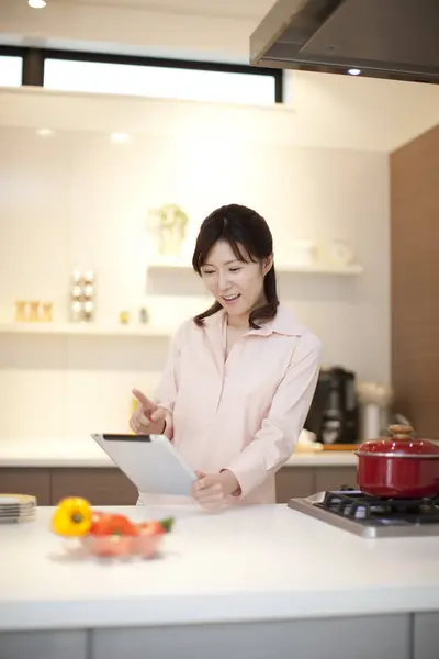 young woman using a tablet in the kitchen