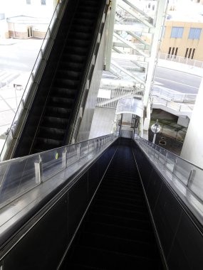 Boş yürüyen merdivenler modern şehir yapısına iniyor.