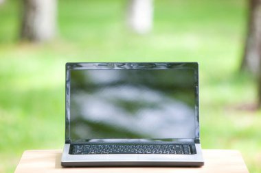 Laptopu yeşil alandaki açık masada kapat.