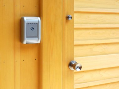 Elektronik kilidi olan sarı ahşap kapı.