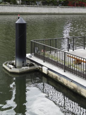 Sakin nehir su yüzeyinin yanındaki demir parmaklıklar.