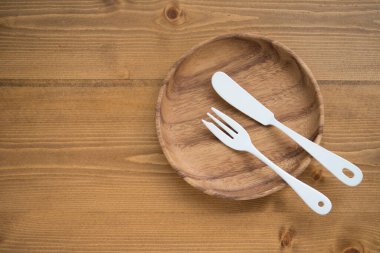 Tahta tabakta beyaz çatal bıçak seti.