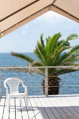 # Deniz kenarında güneşli, boş bir sandalye # 