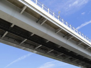 Mavi gökyüzü arkaplanındaki modern köprünün düşük açılı görüntüsü