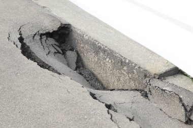 Hasarlı beton yol kenarı boyunca büyük bir çatlak oluşuyor.