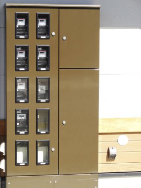 Birden fazla küçük bölmesi olan kahverengi metal dolap ünitesi.