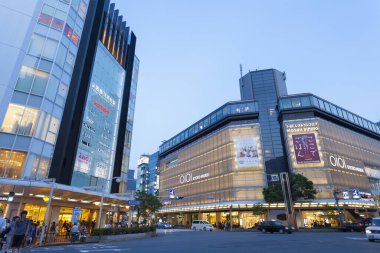 Tokyo 'da modern binaların önünden geçen insanlar