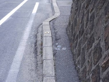 Beyaz yol çizgileri ve şehirdeki eski taş duvar