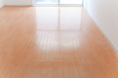 Cilalı ahşap zemin ve parlak pencereli boş oda