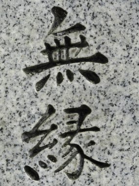 Gri granit taş yüzeyine oyulmuş siyah Çinli karakterler.