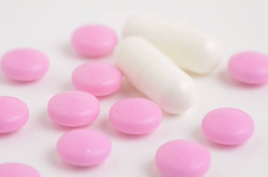 Beyaz arkaplandaki tabletlerin, hapların ve kapsüllerin yakın plan görüntüsü      