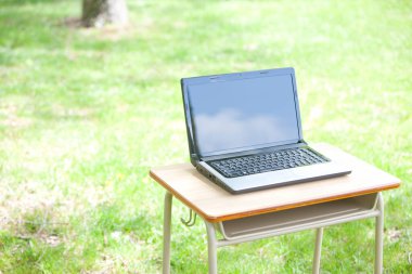 Laptopu yeşil alandaki açık masada kapat.