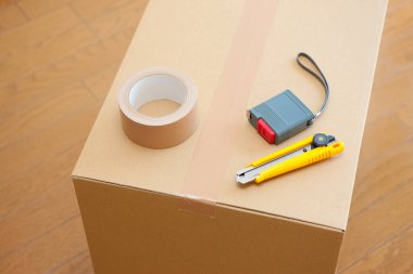 Boş odadaki karton kutudaki araçların yakın görüntüsü. yeni ev kavramı        