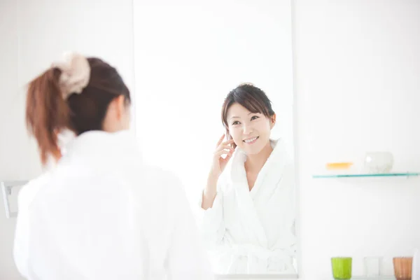トイレで鏡を見ている若い日本人女性 — ストック写真