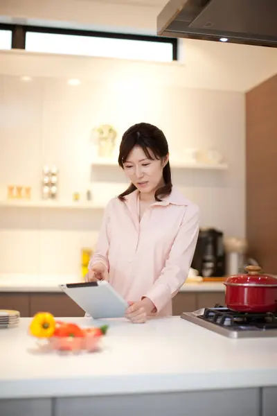 young woman with tablet  in kitchen