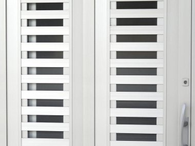Yatay dikdörtgen levhaları olan modern beyaz metal kapı.