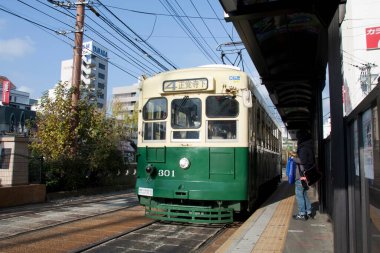 Gündüz vakti şehirde klasik yeşil tramvay 