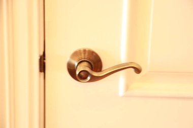 Beyaz ahşap kapının metal kapı kolu.