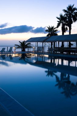 Yüzme havuzlu tropikal deniz tatil köyünün akşam manzarası