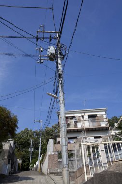 Binaların ve gökyüzünün üzerinde yüksek voltajlı elektrik hatları 