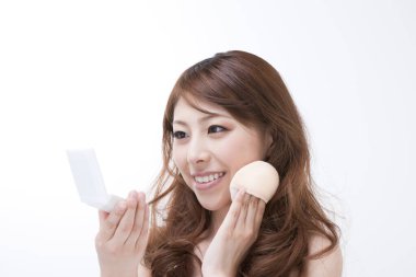 Genç Asyalı kadının yakın plan portresi. Arka planda kızarıklık uyguluyor.