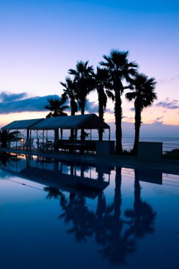 Yüzme havuzlu tropikal deniz tatil köyünün akşam manzarası