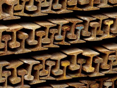 Paslı çelik rayların istiflenmesi tekrar eden endüstriyel desenler yaratıyor