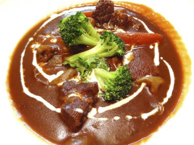 Brokoli ve havuçla süslenmiş zengin biftek güveci.