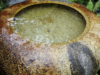 Büyük yıpranmış taş havzası açık havada temiz su tutuyor.