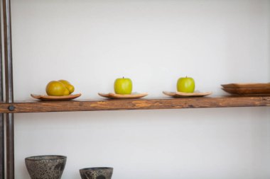 Elma ve limon sergilenen ahşap raf