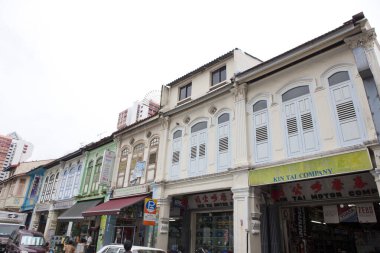 Süslü cepheli ve park edilmiş arabalı renkli dükkanlar.