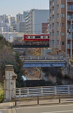 Demiryolu hattı Japonya 'daki büyük bir şehir merkezini keserken, mimari rayları çerçeveliyor.