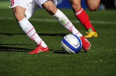 Spor giyim sektöründe futbol oyuncularının bacakları çimlerin üzerinde top oynuyorlar.                 