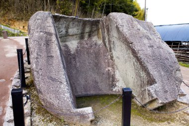 Kırsal yolun yakınında duran büyük antik taş bir anıt.