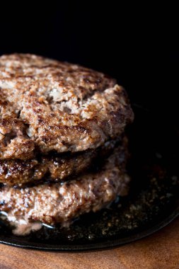 Arka planda pişmiş lezzetli hamburgerler, kapatın.