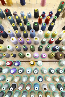 Arkaplanda renkli dikiş iplikleri ve iğneler var. Yakın plan..