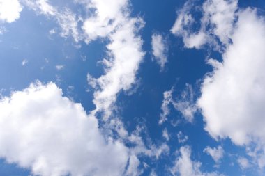 Mavi gökyüzü arka planında beyaz tüylü kümülüs bulutları       